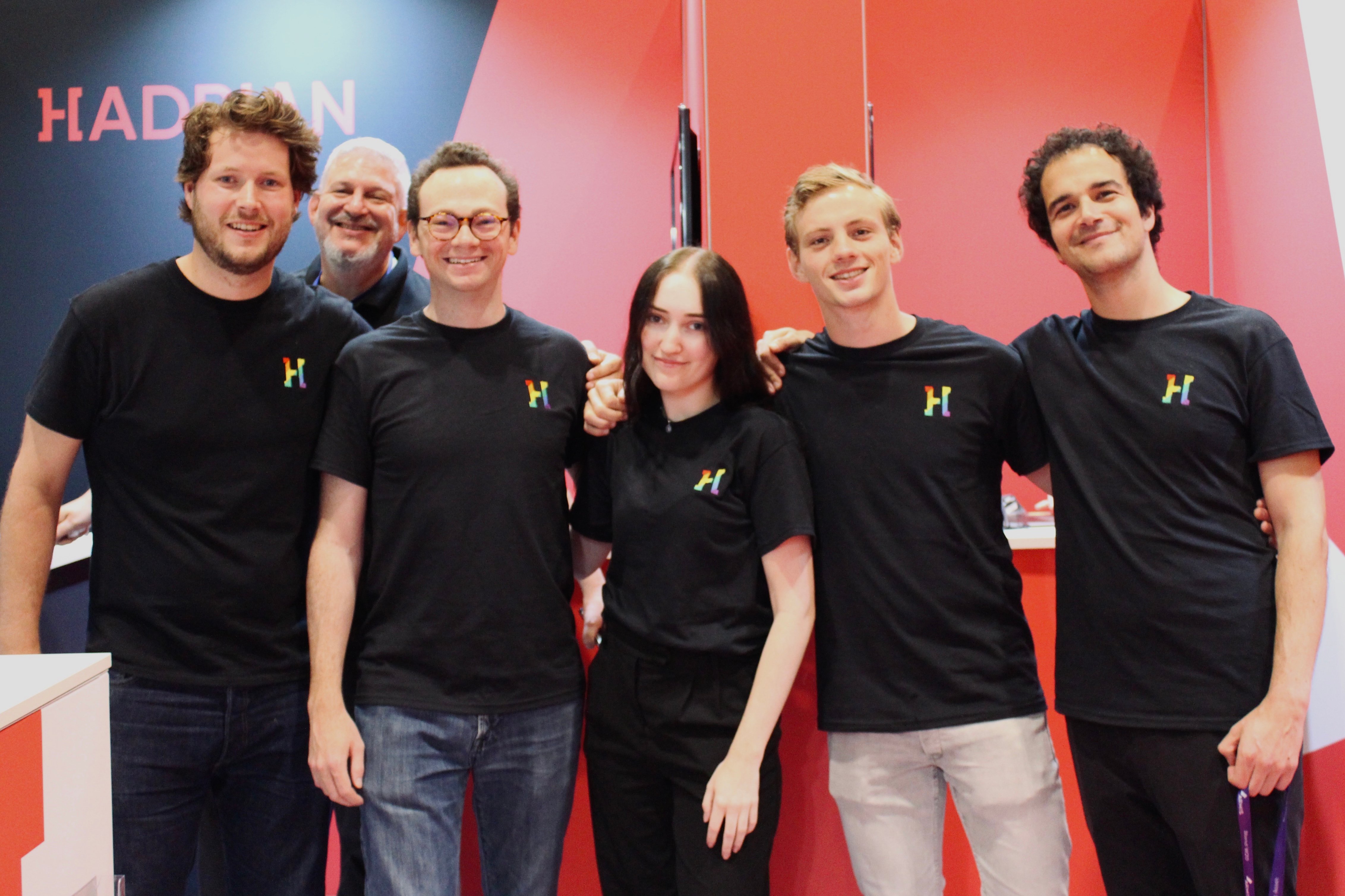 A photo of Hadrian team members standing at Blackhat London in Hadrian Pride t-shirts.
